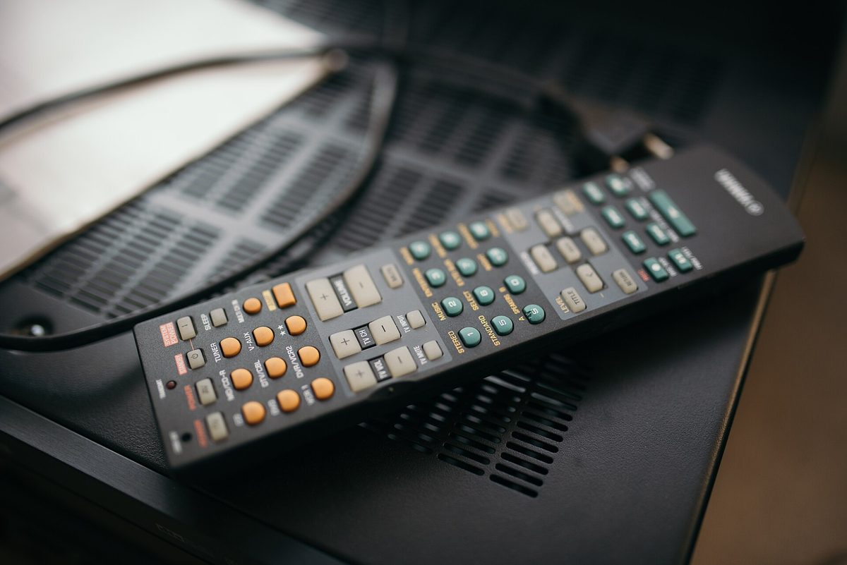 Sohva television edessä; ruudun vasen puolisko näyttää suoraa jalkapalloa ja oikea suoratoistokirjaston elokuvajulisteita